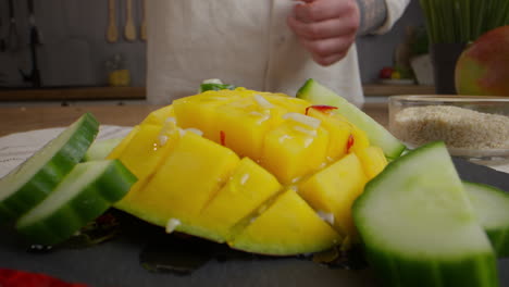 chef preparing a mango and cucumber salad
