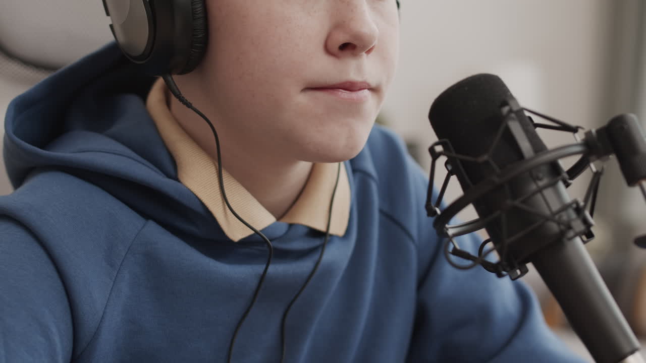 Dreng, der optager en podcast med mikrofon og hovedtelefoner