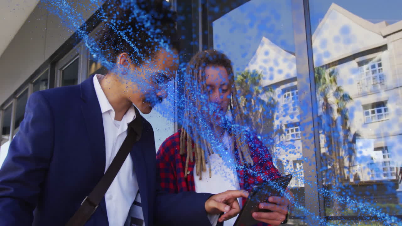 Colleagues pointing at smartphone outside office, demonstrating AR technology with blue particles