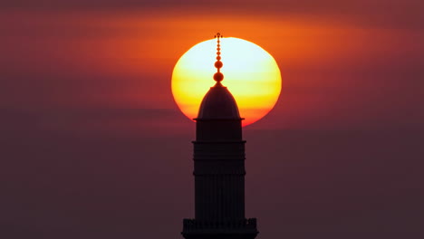minaret silhouette against a fiery sunset