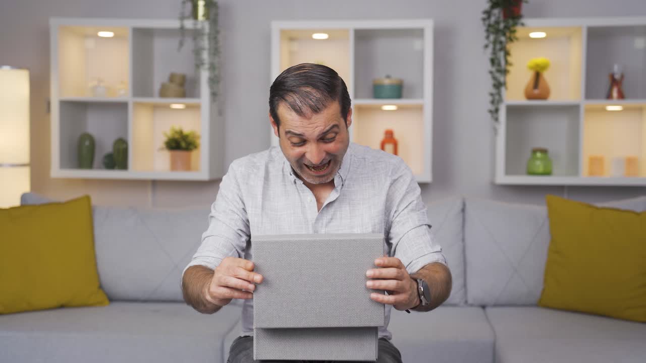 hombre feliz y alegre abriendo el paquete de regalos.
