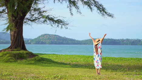 Woman-with-Flower-Dress-Standing-by-the-Sea-Spreading-Arms