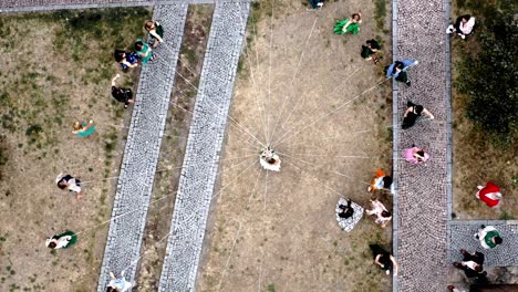 Wedding-guests-tied-to-bride-with-white-ribbons-going-around-in-circle