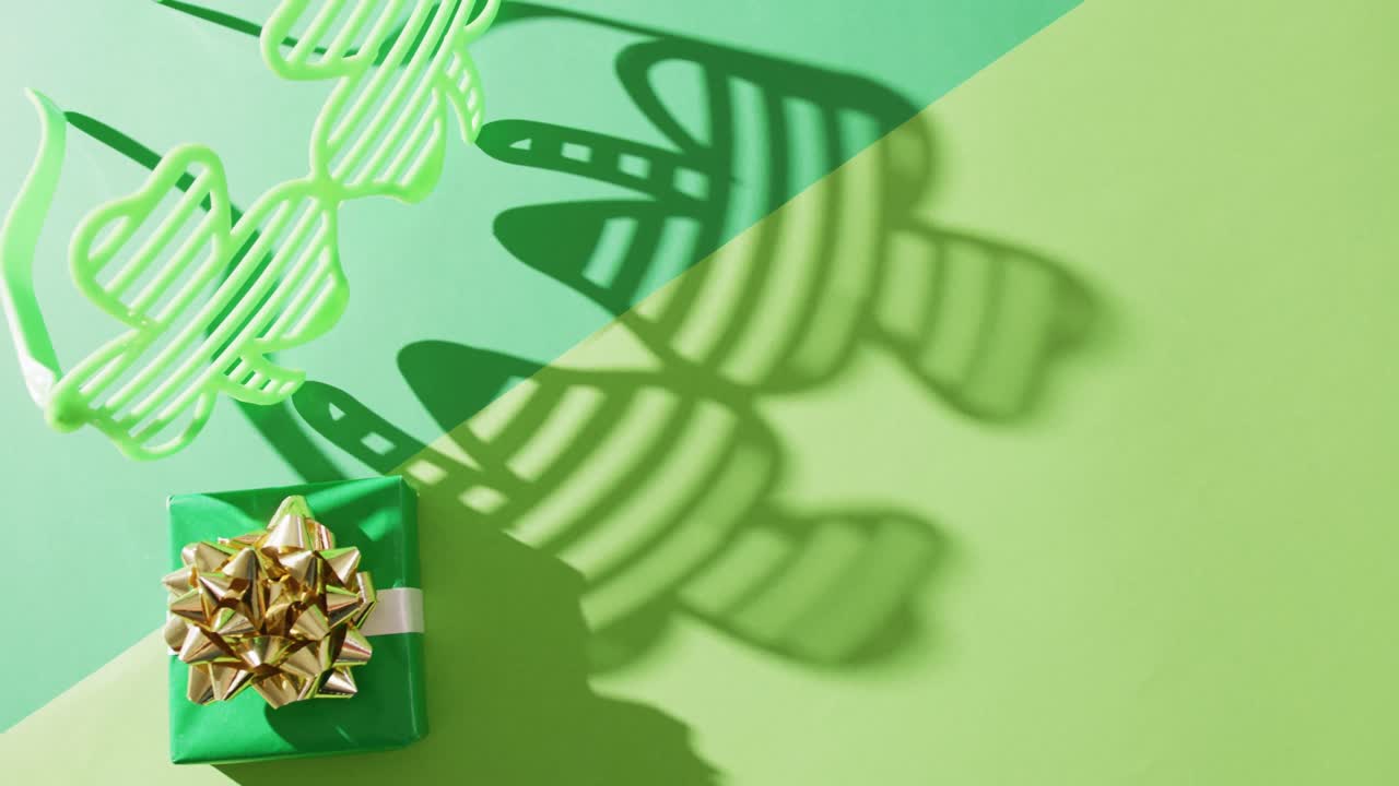Video of st patrick's green shamrock glasses and present with copy space on green background
