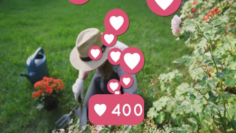 Animation-of-heart-emojis-over-caucasian-woman-gardening
