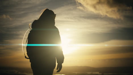 silhouette shot of a female hiker taking in the sunrise views at the peak of lovstakken