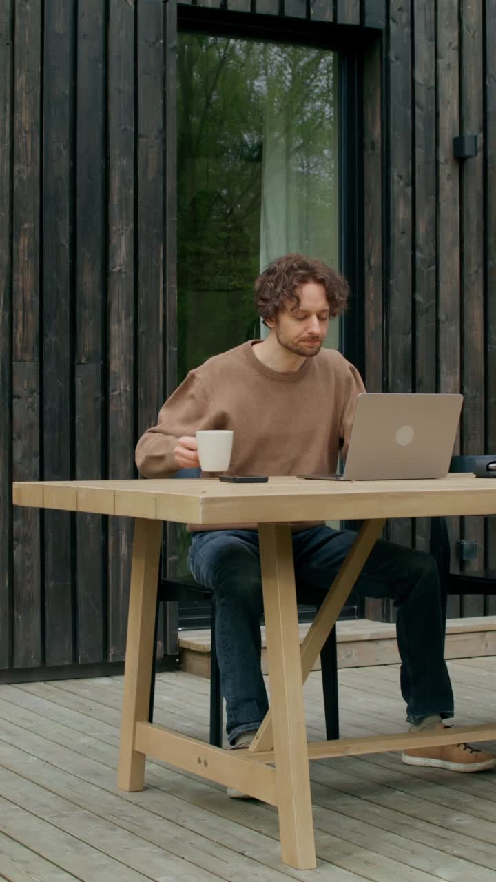 hombre trabajando en una computadora portátil en una cubierta de madera