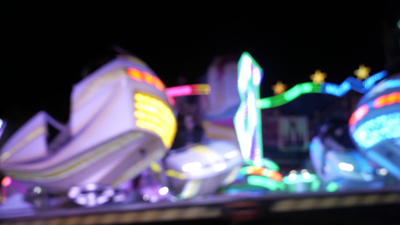 Illuminated high speed carousel spinning in circle,people dizzling,static close up