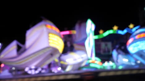illuminated high speed carousel spinning in circle,people dizzling,static close up
