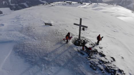 hermoso efecto de paralaje de drones en la cumbre de la montaña en austria con un grupo de snowboarders