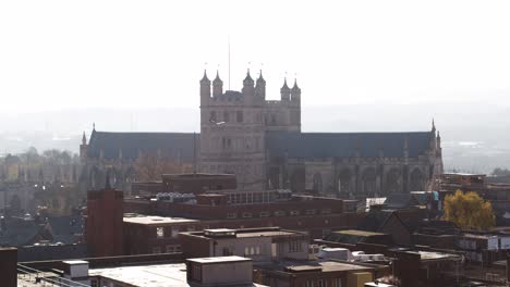 rising aerial of a silhouetted cathedral against a sunny backdrop in a city setting