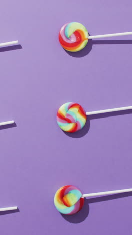 video of rows multicoloured lollipops on blue background