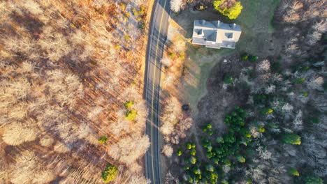 Eine-Drohnenaufnahme-Einer-Straße,-Die-Im-Herbst-Und-Winter-In-Neuengland-Durch-Den-Wald-Führt