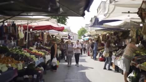 discover a bustling market filled with vibrant stalls and a variety of fresh fruits and vegetables as shoppers enjoy their day. the lively atmosphere captures the essence of local culture.
