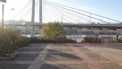 slow walk up to a bench looking at the willamette river and the tilikum bridge in portalnd oregon.