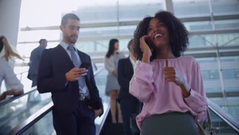 businesswoman using mobile phone on escalator in a modern office 4k