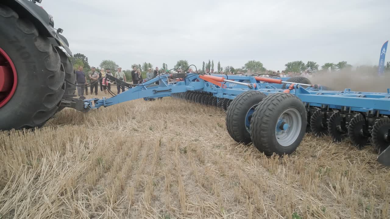 전시회에서 농업 기계의 시연. 트랙터는 현장에서 작동하여 그들의 능력과 성능을 전시합니다.