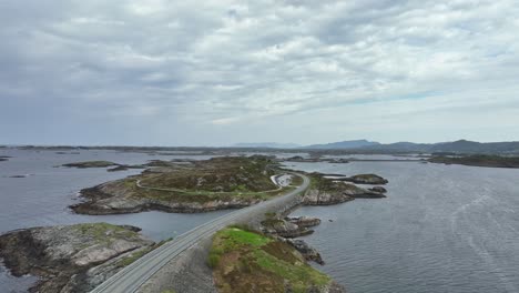 aerial along the famous atlantic ocean road in norway - low altitude aerial crossing over road and looking north in coastal landscape