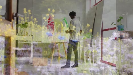 animation of african american man painting over landscape