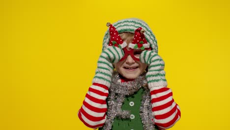 kid girl in christmas elf santa helper costume dancing, fooling around. new year holiday celebration