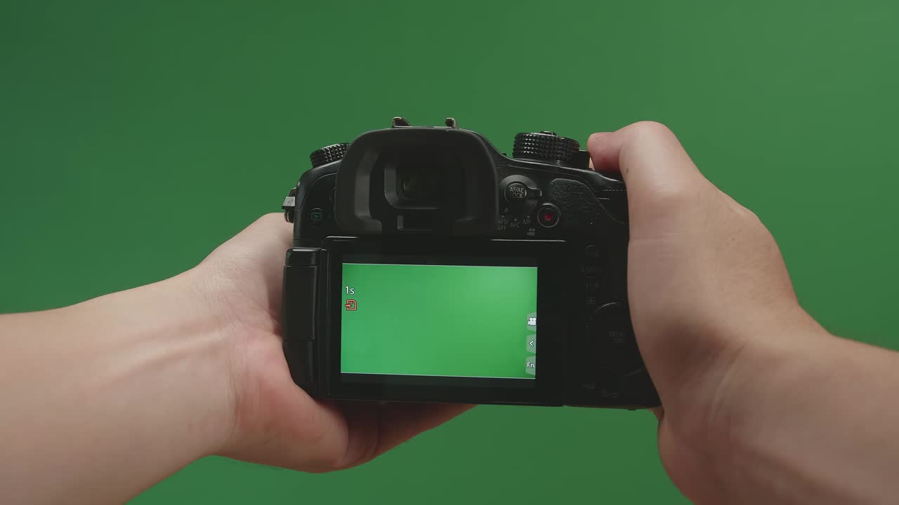 Male Hands Recording Video With Green Screen Display Camera In Green Background