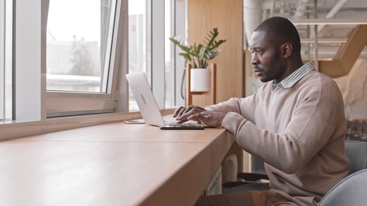 Afro American Businessman Working on Laptop in Cafe