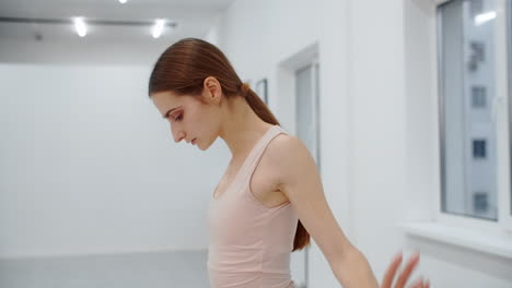 ballet dancer stretching in studio