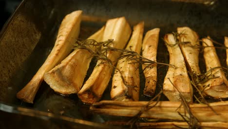 roasted parsnips in tray with pepper and rosemary