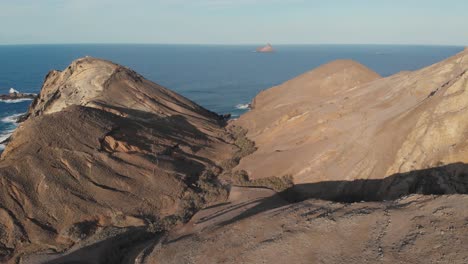 Aerial-forward-over-rocky-arid-promontory-of-Porto-Santo-island-in-Portugal