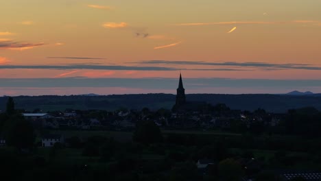 Como-Un-Cuchillo,-La-Alta-Aguja-De-La-Iglesia-Atraviesa-El-Cambiante-Horizonte-Del-Atardecer.