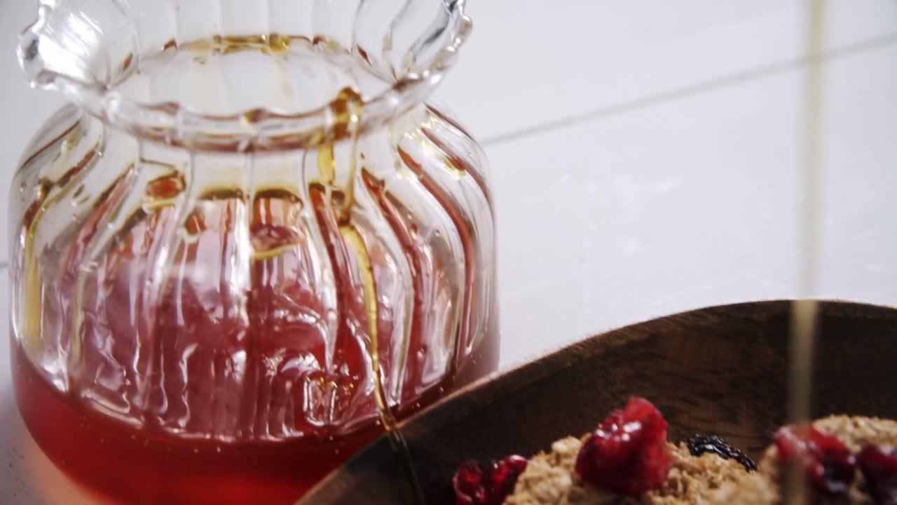 miel vertiendo en un tazón de cereales 4k