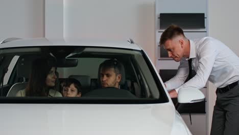 family discussing car purchase in showroom