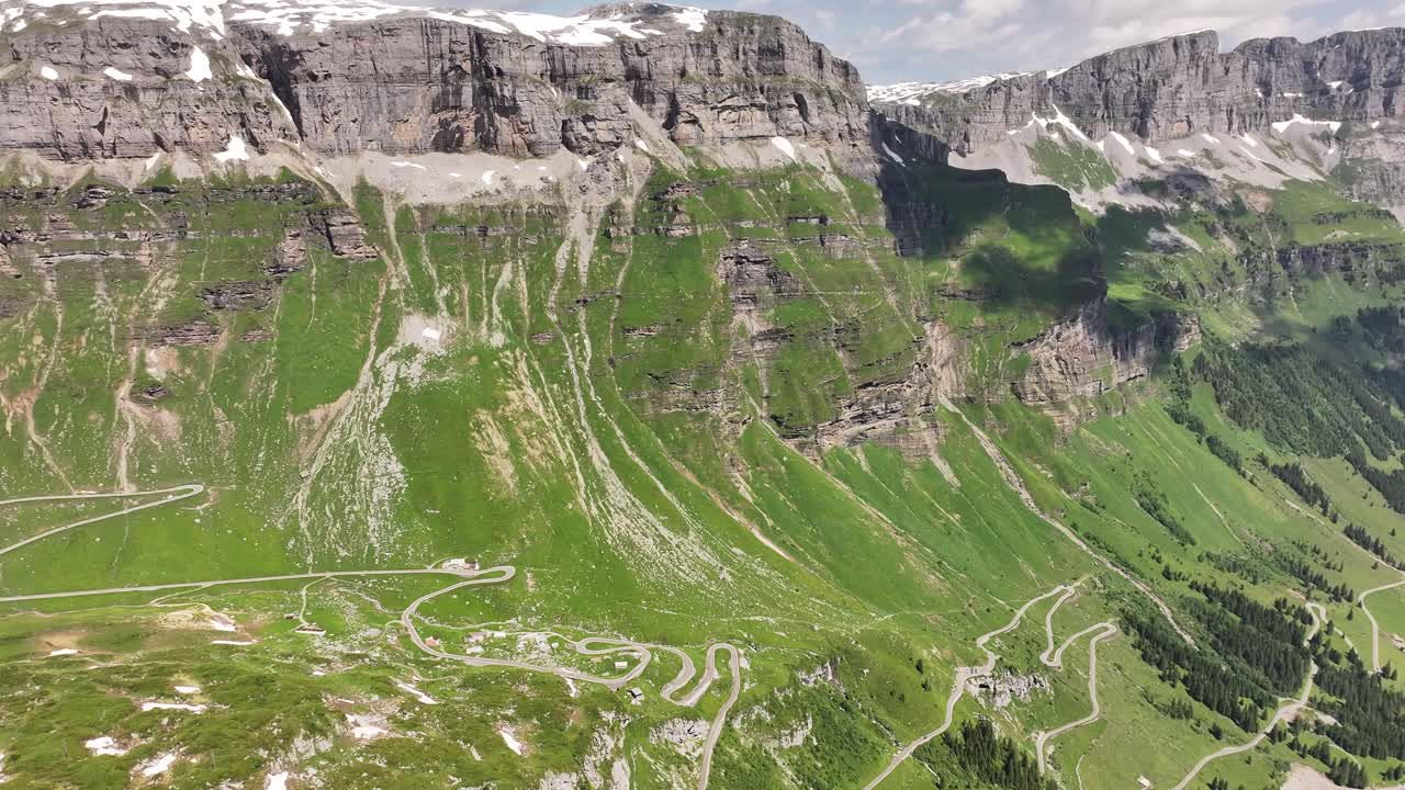 vista aérea de la majestuosa cordillera y el paisaje de klausenpass, urner-boden, suiza, con altos acantilados y un valle atravesado por carreteras