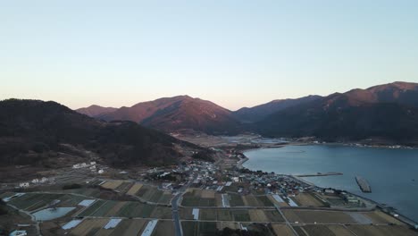 Aerial-view-of-farming-fields-and-small-settlement-of-Namhae,-South-Korea-coastal
