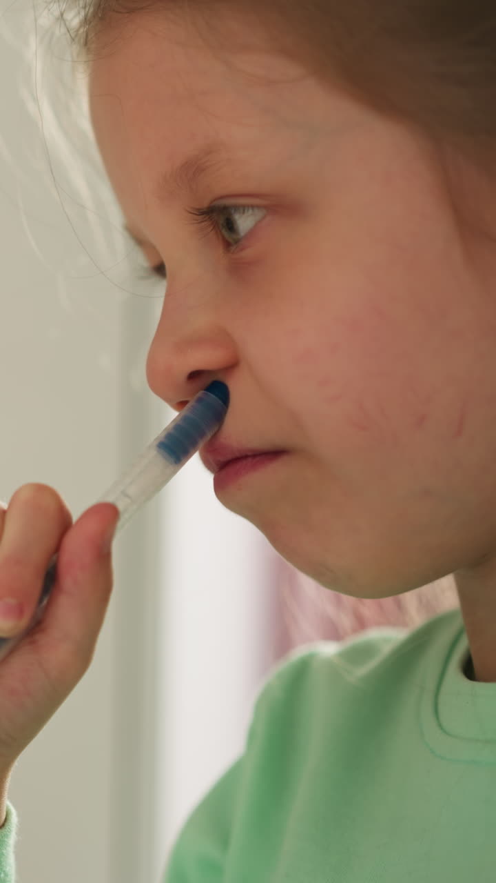 Pensive schoolchild presses pen tip to nose and purses lips considering task. Diligent little girl do homework. Educational process in primary school closeup