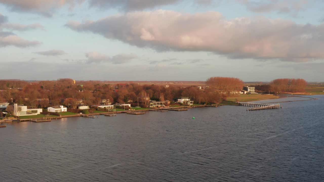 Vacation homes located at a lake during winter. Low to high angle drone shot