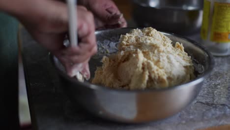 ingredientes de masa cruda mezclados con cuchara de hornear en un cuenco de acero en la mesa de la cocina, filmados en primer plano en cámara lenta.