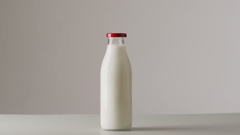 video of glass bottles of milk on white background