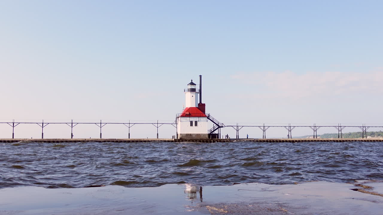 Light house during early sunset on a summer day water splashing