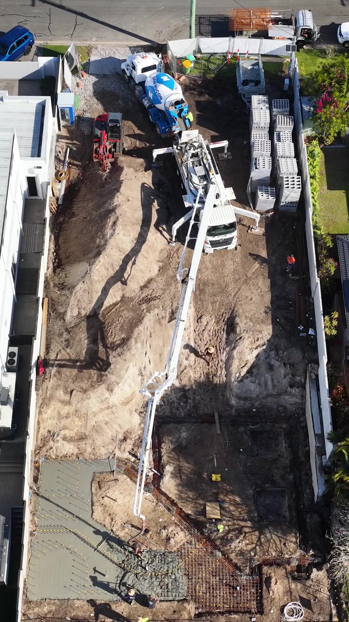 Toma aérea con dron de un camión bomba de hormigón vertiendo cimientos en Broadbeach Waters