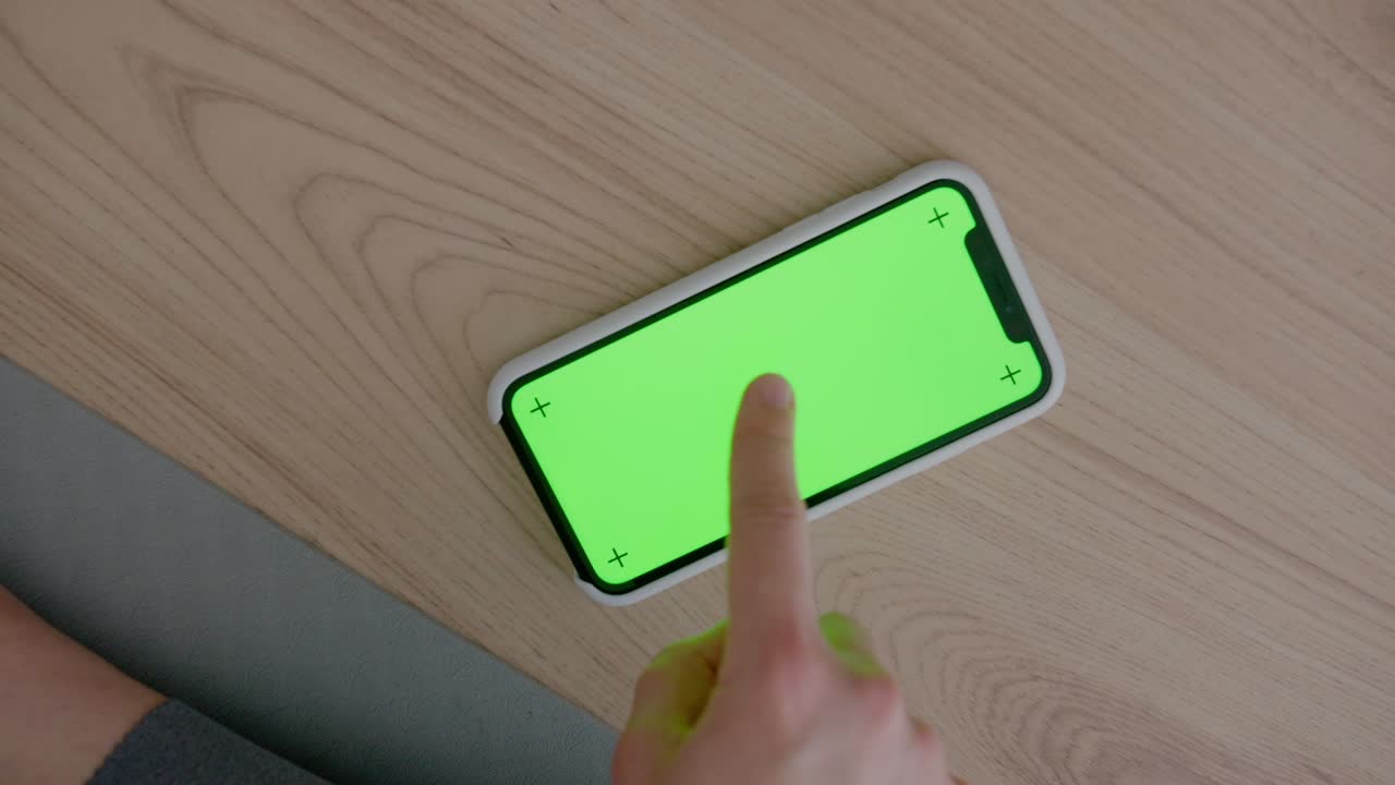 녹색 화면 을 가진 전화기 가 바닥 에 놓여 있다