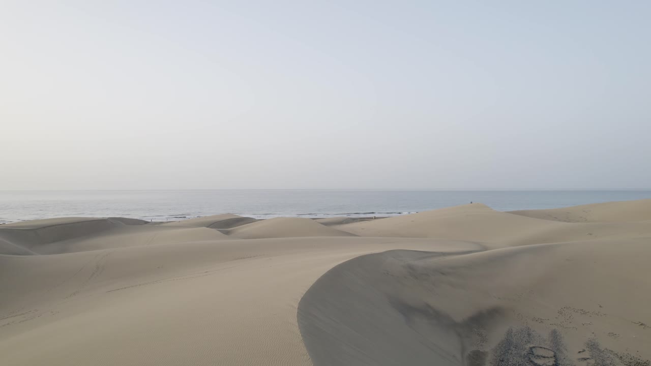 Drone flight on the island of Gran Canaria over the dunes of Maspalomas towards the ocean