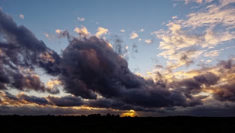 timelapse taken by drone shows clouds colored by the rays of the sunset, with changing shapes and colors while flying over the landscape, offering a breathtaking view of the clouds and the sunset