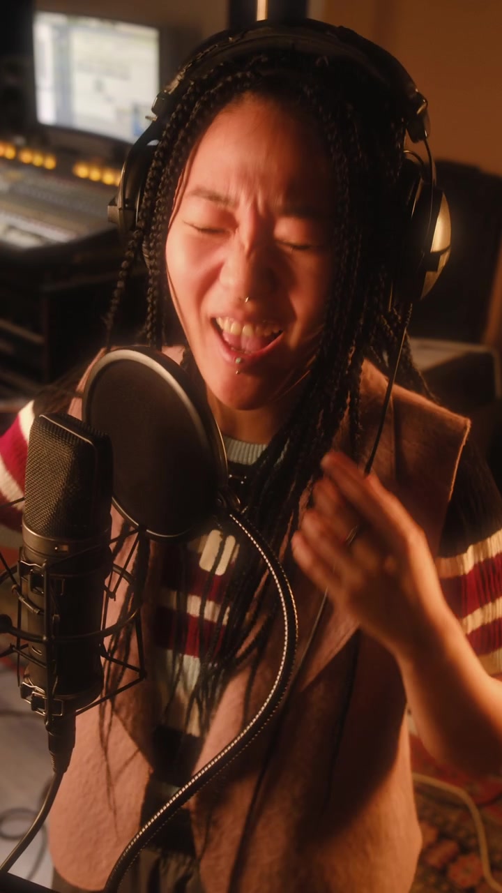 Asian Female Vocalist Singing Passionately into Mic in Recording Studio