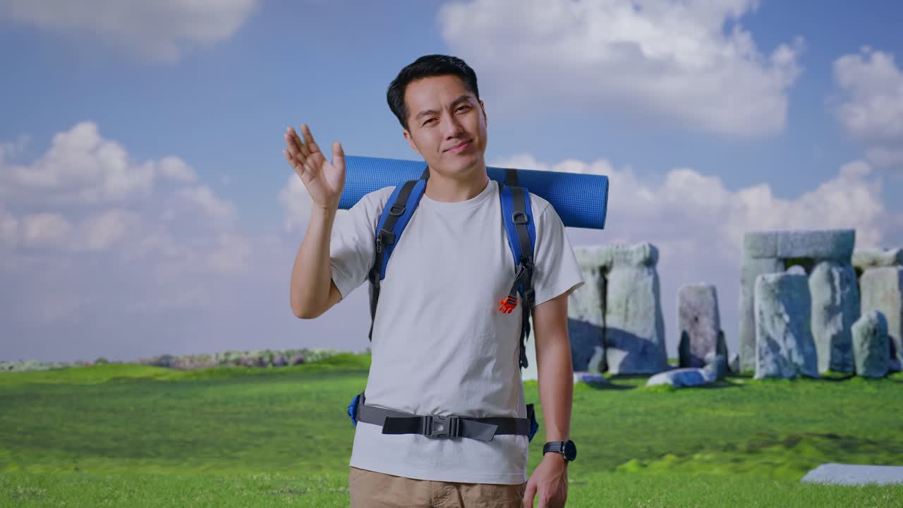 Asian Male Hiker With Mountaineering Backpack Waving Hand And Saying Bye While Traveling In Stonehenge