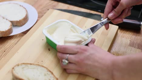 spreading cream cheese or butter on bread for breakfast
