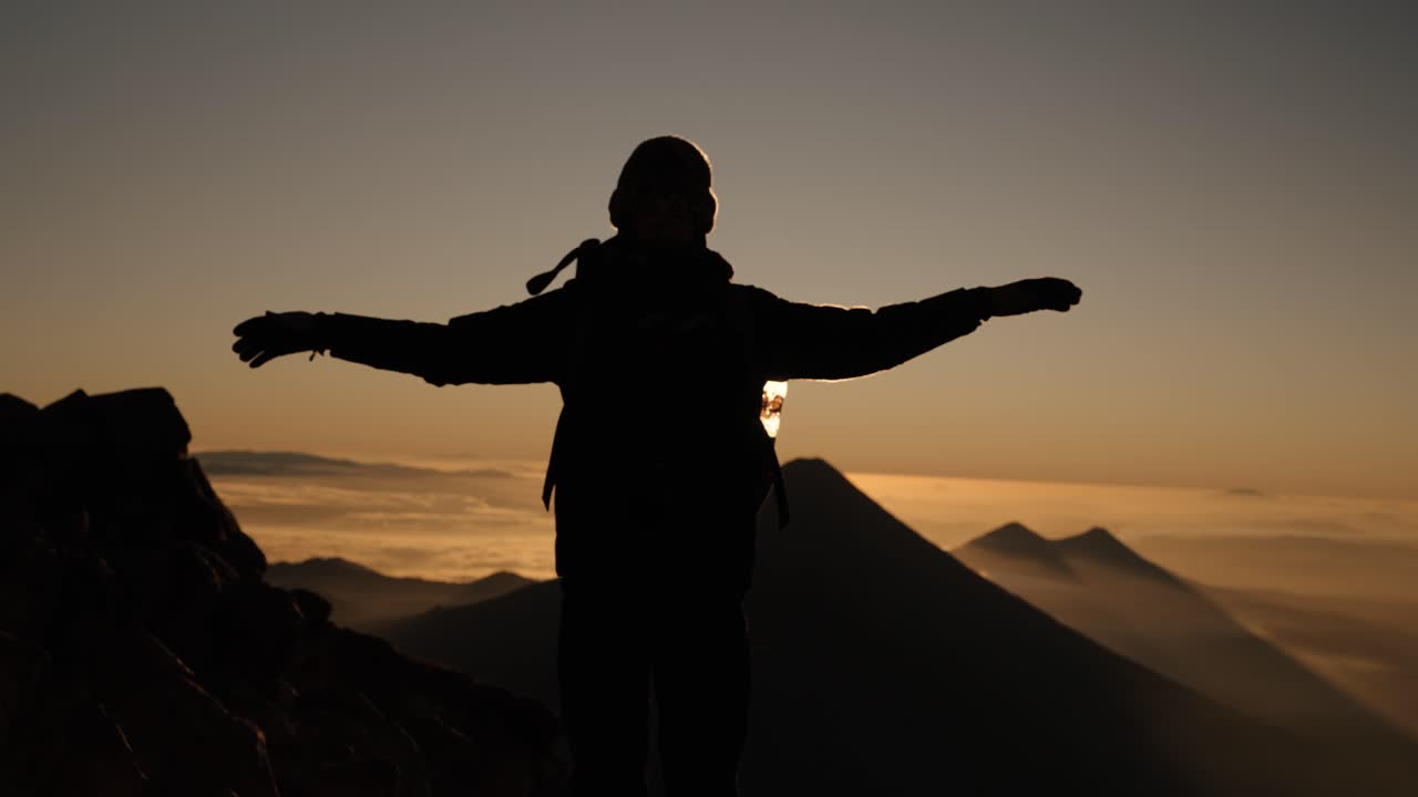 Fotturist kjenner vinden på Acatenango-toppen under soloppgang i Guatemala.