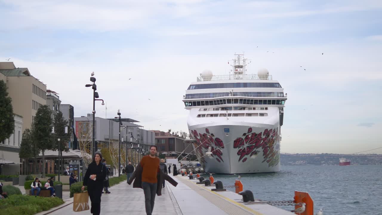 항구 에 정박 한 크루즈 선박 과 해안 에서 고 있는 사람 들