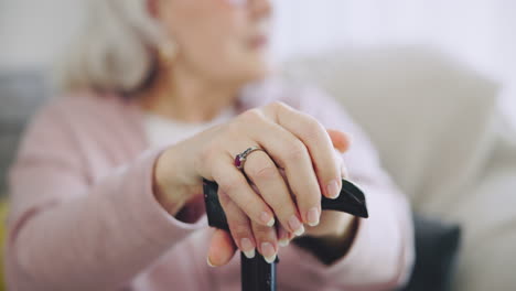 cane, hands and elderly woman in home on living