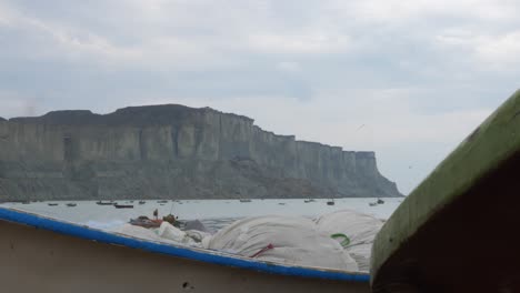 Slow-Pan-Left-Reveal-Of-Seagulls-Flying-Above-Beach-In-Gwadar-On-Coast-Of-Balochistan